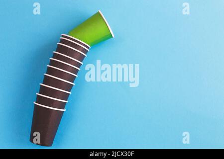 Umweltfreundliche Einwegbecher aus braunem und grünem Papier auf blauem Hintergrund. Ökologisches Konzept. Stockfoto