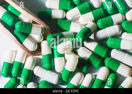 Medizin grüne Pillen auf weißem Hintergrund auf Holzlöffel. Sortierte Pharma Stockfoto