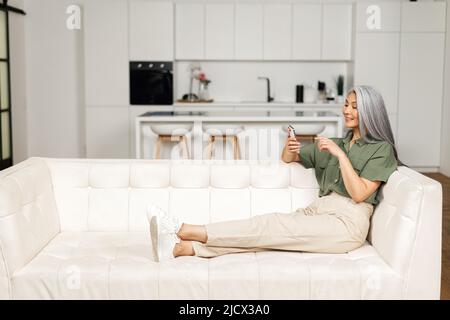 Happy Beautiful Senior Woman verwendet ein Smartphone für Videoanrufe zu Familie, Freunden oder Dating online. Ältere Dame hält das Telefon und mit App für Video-Kommunikation, Online-Meeting Stockfoto