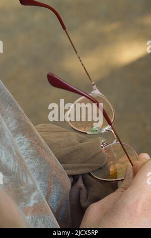 Frau putzt Gläser mit T-Shirt als Reinigungstuch Nahaufnahme Stockfoto