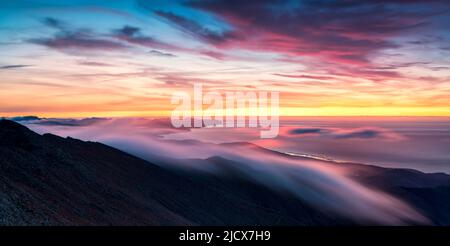 Lange Exposition von Wolken und Nebel in den bunten Himmel bei Sonnenaufgang über Pico de la Zarza, Fuerteventura, Kanarische Inseln, Spanien, Atlantik, Europa Stockfoto