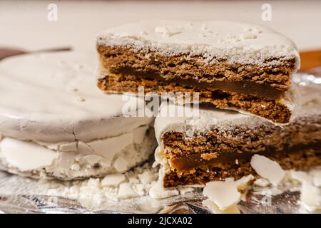 Typisch argentinische weiße Alfajores, gefüllt mit Dulce de leche und mit einer harten Glasur überzogen. Traditionelles Essen. Stockfoto