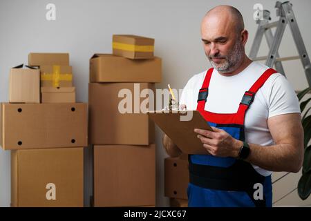 Mann mittleren Alters in Uniform Notizen auf Zwischenablage Stockfoto