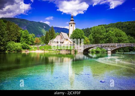 Bohinj See, Slowenien. Kirche des heiligen Johannes des Täufers mit Brücke über den Fluss Sava. Triglav Nationalpark in den Julischen Alpen. Stockfoto