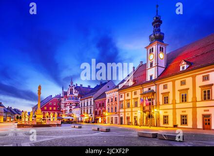 Maribor, Slowenien. Hauptplatz in der Dämmerung mit Pestsäule, slowenischer Reisescheinwerfer. Stockfoto