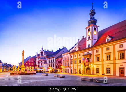 Maribor, Slowenien. Hauptplatz in der Dämmerung mit Pestsäule, slowenischer Reisescheinwerfer. Stockfoto