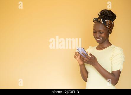 Seitenportrait einer jungen Frau, die auf ihrem Smartphone schmillt und tippt Stockfoto