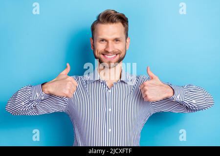 Porträt eines positiven Mannes zwei Hände Finger zeigen Daumen nach oben isoliert auf blauem Hintergrund Stockfoto