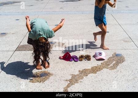 Junge Mädchen kühlen sich ab, indem sie in Toulouse mit städtischen Bodenverneblern, Hitzewelle und 40 Grad Celsius spielen. Frankreich am 15. Juni 2022. Foto von Patricia Huchot-Boissier/ABACAPRESS.COM Stockfoto