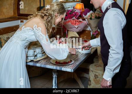 Braut und Bräutigam schneiden den Kuchen Stockfoto