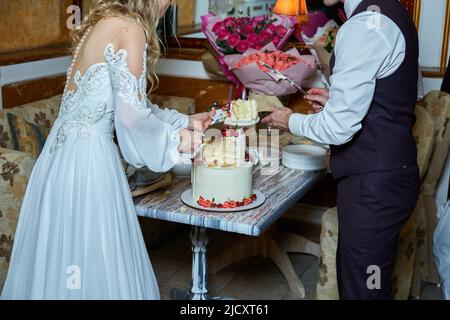 Braut und Bräutigam schneiden den Kuchen Stockfoto