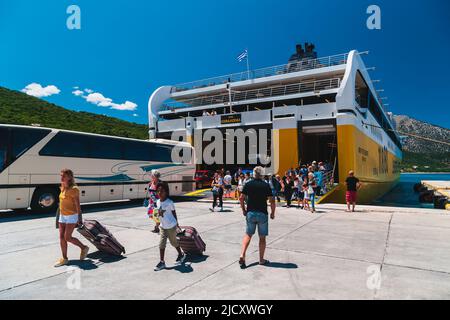 Poros, Insel Cefalonia, Griechenland - Juli 17 2019: Ausschiffung von Autos, Bussen und Passagieren von der Fähre der Levante Ferries Group, die im Hafen von Poros anlegt. Heller Sommertag, Reisekonzept. Stockfoto