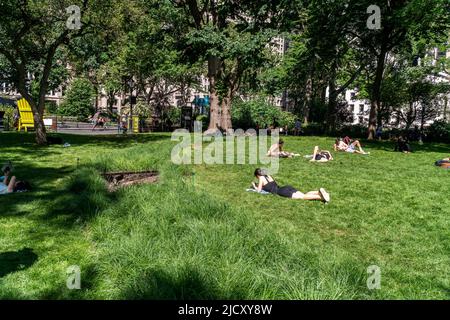 Am Freitag, den 10. Juni 2022, sonnen sich die Menschen auf dem Oval Lawn im Madison Square Park in New York rund um die Installation von Cristina Iglesias „Landscape and Memory“. Die öffentliche Kunstinstallation stellt Cedar Creek nach, ein Gewässer, das einst unter dem Park floss. Die Installation läuft bis Dezember 4. (© Richard B. Levine) Stockfoto