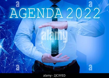 Textschild mit Agenda 2022. Geschäftsidee Liste der Aktivitäten, um die sie aufgenommen werden Geschäftsmann mit offenen Palmen stellt Stockfoto