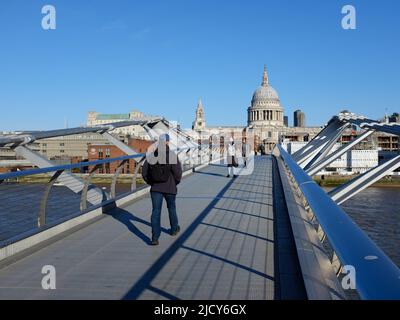 Menschen, die auf der Millennium Bridge von der Tate Modern zur St. Paul's Cathedral in London spazieren Stockfoto