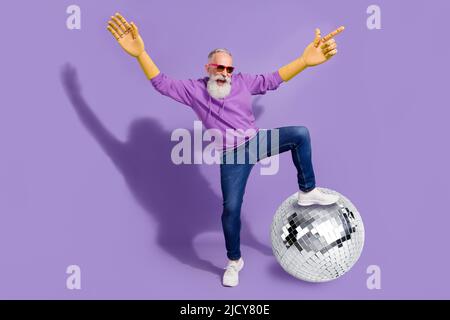 In voller Länge Collage Foto von verrückten reifen Mann haben Spaß im Nachtclub Schritt auf riesige Disco Ball isoliert auf violetten Hintergrund Stockfoto