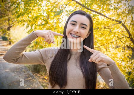 Schönes lächelndes Mädchen, das Retainer zeigt, Zahnspangen. Kieferorthopädie Dental Thema, Methoden der Zähne Bisskorrektur, Close-Up Stockfoto