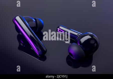 Kabellose Kopfhörer auf schwarzem Hintergrund. Nahaufnahme des schnurlosen Headsets auf schwarzem Hintergrund isoliert. Stockfoto