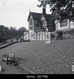 1940s, historisch, Blick von den Terrassen der Rückseite der Bramall Hall, Bramhall, Stockport, England, Großbritannien. Das aus dem 14.. Jahrhundert stammende, mit Fachwerkrahmen umrahmte Tudor-Herrenhaus, das später erweitert wurde, wurde 1935 von der Stadtverwaltung erworben und zu einem Museum. Die Familie Davenport, von der angenommen wird, dass sie das Haus gebaut hat, hielt das Herrenhaus über 500 Jahre lang. Stockfoto