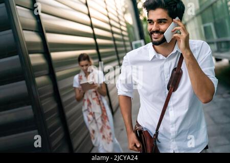 Porträt erfolgreicher fröhlicher junger Geschäftsleute, die im Freien sprechen Stockfoto