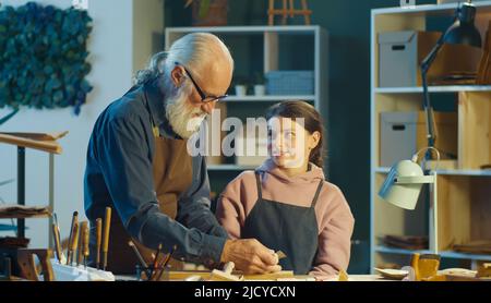 Fürsorglicher Großvater mit seiner Enkelin im Teenage-Alter verbringt Zeit miteinander. Hobby Stockfoto