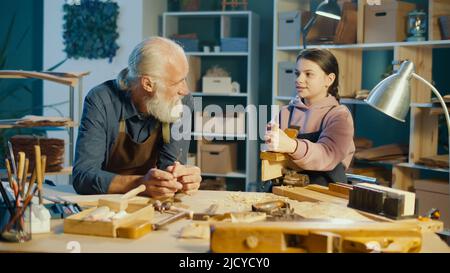 Fürsorglicher Großvater mit seiner Enkelin im Teenage-Alter verbringt Zeit miteinander. Hobby Stockfoto