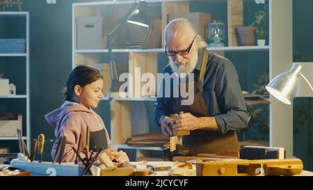 Fürsorglicher Großvater mit seiner Enkelin im Teenage-Alter verbringt Zeit miteinander. Hobby Stockfoto