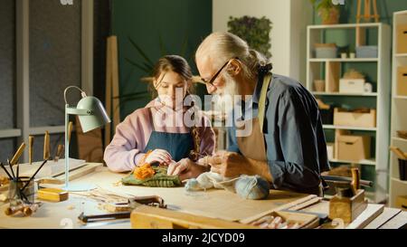 Fürsorglicher Großvater mit seiner Enkelin im Teenage-Alter verbringt Zeit miteinander. Hobby Stockfoto