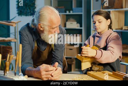 Fürsorglicher Großvater mit seiner Enkelin im Teenage-Alter verbringt Zeit miteinander. Hobby Stockfoto