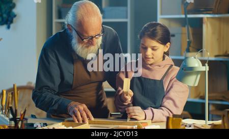 Fürsorglicher Großvater mit seiner Enkelin im Teenage-Alter verbringt Zeit miteinander. Hobby Stockfoto