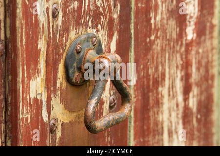 Alte und verrostete Türgriff auf einem braun bemalten Holz Tür Stockfoto