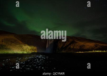 Aurora Borealis, Nordlichter, über dem Wasserfall Skogafoss, Island. Stockfoto