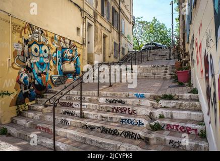 Marseille, Frankreich, Mai 2022, Blick auf eine schmale Straße mit Wandmalereien im Viertel Le Panier Stockfoto