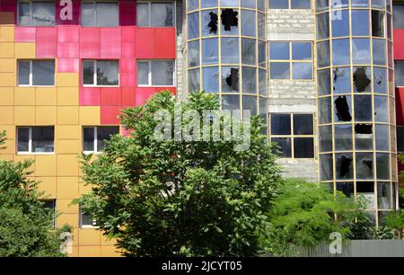 Zerbrochenes Glas eines Bürogebäudes. Modernes Geschäftsgebäude mit kaputten Fenstern Stockfoto