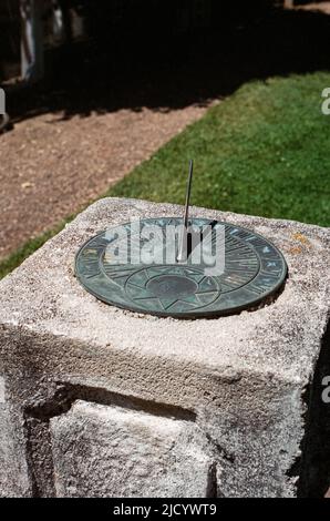 Sonnenuhr aus Messing, montiert auf einem dekorativen Betonsockel im Garten des Fuller Estate. North Hampton, New Hampshire, USA. Stockfoto