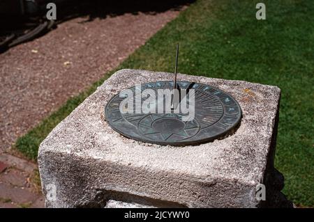 Sonnenuhr aus Messing, montiert auf einem dekorativen Betonsockel im Garten des Fuller Estate. North Hampton, New Hampshire, USA. Stockfoto