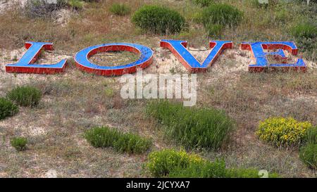 WORTLIEBE in plastischen Großbuchstaben auf dem Boden-327 Stockfoto