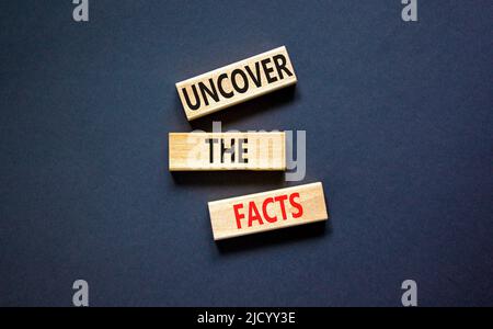 Entdecken Sie das Facts-Symbol. Concept Words enthüllen die Fakten auf Holzblöcken auf einem schönen schwarzen Tisch auf schwarzem Hintergrund. Und die Fakten aufdecken Stockfoto