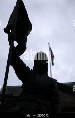 Selkirk, Großbritannien. 16.. Juni 2022. Selkirk, Großbritannien., . Selkirk Common Riding 2022. Donnerstag, die Nacht vor dem Morgen. Das Fletcher-Denkmal, ein Denkmal der Vergangenheit und die historische Figur, die aus der Schlacht von Flooded im Jahr 1513 zurückgekehrt ist, steht vor der Victoria Hall (Quelle: Rob Gray/Alamy Live News Stockfoto