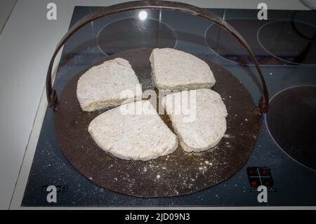 Ein Blick auf das Leben in Neuseeland. Traditionelle irische Soda-Brot-Farls, frisch gebacken auf einer traditionellen gusseisernen Grillplatte. Stockfoto