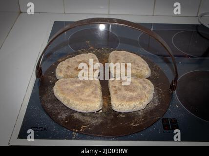 Ein Blick auf das Leben in Neuseeland. Traditionelle irische Soda-Brot-Farls, frisch gebacken auf einer traditionellen gusseisernen Grillplatte. Stockfoto