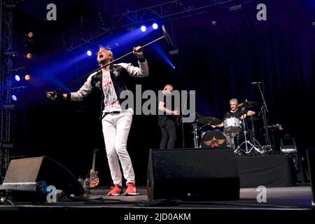 Newport, Großbritannien. 16.. Juni 2022. Von L-R Sänger Rick Parfitt Jnr, Sohn des verstorbenen Rick Parfitt, Gitarrist mit Status Quo, Gitarrist Jo und Schlagzeuger Alex Toff, die live auf der Bühne mit der Rick Parfitt Jnr Band bei der Eröffnung in The Big Top während des Isle of Wight Festivals auftreten. (Foto von Dawn Fletcher-Park/SOPA Images/Sipa USA) Quelle: SIPA USA/Alamy Live News Stockfoto