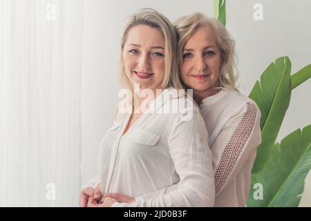 Zwei europäische Frauen umarmen und haben eine tolle Zeit zusammen Medium closeup drinnen Wohlbefinden Konzept. Hochwertige Fotos Stockfoto