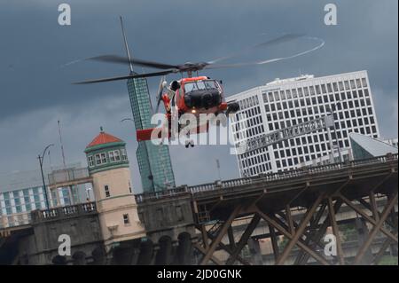 Eine Küstenwache-Luftstation Astoria MH-60 Jayhawk-Besatzung fährt einen Flugüberlebenstechniker in Portland, Oregon, 11. Juni 2022. Die Luftbesatzung hatte während des Portland Rose Festivals eine Such- und Rettungsdemonstration durchgeführt. (USA Foto der Küstenwache von Petty Officer, Klasse 3., Diolanda Caballero) Stockfoto