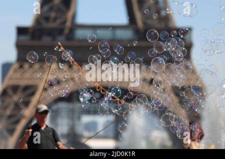 Paris, Frankreich. 16.. Juni 2022. Ein Straßenkünstler macht am 16. Juni 2022 Seifenblasen in der Nähe des Eiffelturms in Paris, Frankreich. Kredit: Gao Jing/Xinhua/Alamy Live Nachrichten Stockfoto