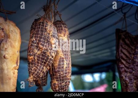 Bild eines serbischen Prsut Schinken, der auf einer Stange auf dem Land in Serbien trocknet. Es ist ähnlich wie der italienische Prosciutto Crudo, ist ein italienischer trocken-gehärteter ha Stockfoto