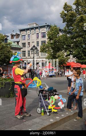 Straßenkünstler unterhalten Touristen am Place Jacques Cartier in Old Montreal im Sommer, Quebec, Kanada. Stockfoto