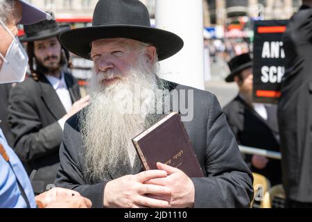 Ein Rabbi spricht vor dem britischen Parlament mit den Bürgern über den Protest gegen das Schulgesetz. Etwa 300 orthodoxe Juden versammelten sich auf dem Parlamentsplatz gegenüber dem Unterhaus, um gegen das Schulgesetz zu protestieren, das derzeit im Oberhaus diskutiert wird. Der Gesetzentwurf zielt auf eine engere zentrale Kontrolle der Bildungseinrichtungen im Vereinigten Königreich ab. Die orthodoxe jüdische Gemeinde ist besorgt, dass die neuen Befugnisse in dem Gesetzentwurf die traditionellen jüdischen Bildungseinrichtungen und Prozesse, die die Grundlage für die jüdische Bildung, insbesondere in Relatio, waren, einschränken oder beschädigen werden Stockfoto