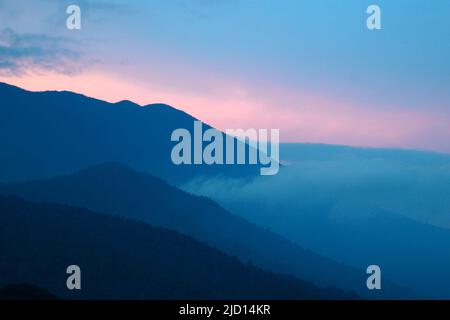 Blick am frühen Morgen auf den Hang des Mount Pangrango und die unteren angrenzenden Hügel im Mount Gede Pangrango Nationalpark, von Cibulao, Tugu Utara, Cisarua, Bogor, Indonesien aus gesehen. Stockfoto