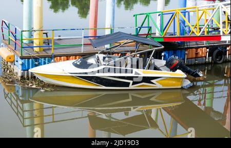 Ein Wakeboard-Boot an einem hölzernen Dock im tlocor Meerestourismus an einem sonnigen Tag. Stockfoto